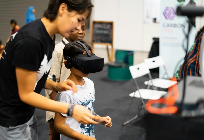 young-boy-using-virtual-reality-gear-with-adult-at-the-digital-fair.jpg